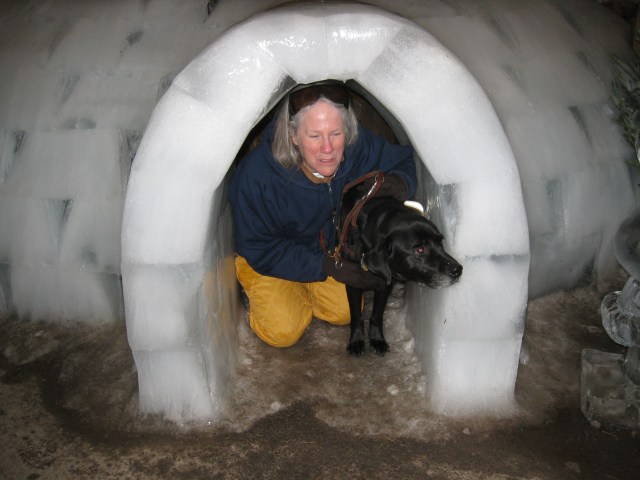 Donna and Hunter Look Out from an icy igloo by Rich Hill