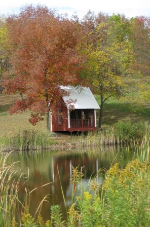 Hills' gingerbread pond shelter flanked by trees in autumn colors: photo by Rich Hill