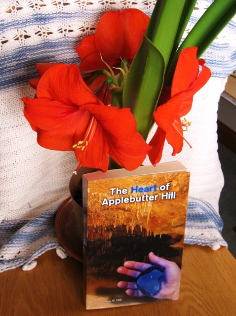Blooming Amarilis with a print copy of The Heart of Applebutter Hill by Donna W. Hill, a fantasy adventure featuring some awesome flowers: photo by Rich Hill.