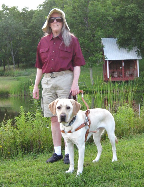 Donna W. Hill & her new yellow Lab guide dog Mo standing by Hill's pond: photo by Rich Hill.