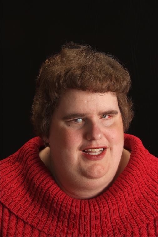 Meredith Burton, author of Blind Beauty and Other Tales of Redemption & Rebecca's Refuge, shown in a Red Sweater: photo courtesy of Meredith Burton.